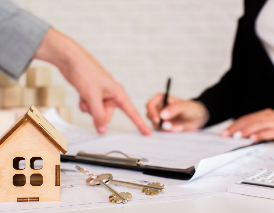 Signature de contrat – AC IMMO Signature d’un contrat immobilier avec un agent et des clés sur la table